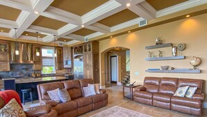 A spacious living area with a brown leather sofa, a matching armchair, and a large rug. - Luxury Construction, Heated Pool on Canal, 3 Minute Walk to sugar sand of FMB! (Fort Myers Beach)