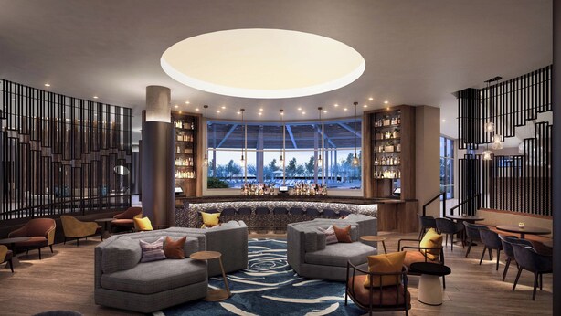 Een moderne loungehoek met banken, stoelen, een bar en een groot raam met uitzicht.