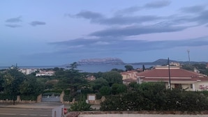 Un pueblo costero con edificios, una señal de alto y vista al mar.