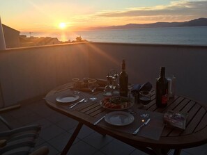 A table set for a meal with a sunset view on a balcony. - Sunset view apartment - One bedroom apartment with balcony and sea view (Postira)