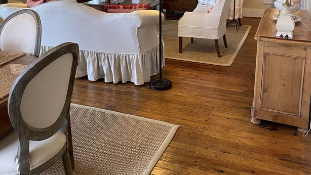 A bedroom with a large bed, two chairs, a wooden wardrobe, and a ceiling fan. - Farm House Inn - Quiet Country Elegance (New Ulm)