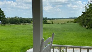 A wooden deck with a white bench overlooking a grassy field. - Farm House Inn - Quiet Country Elegance (New Ulm)