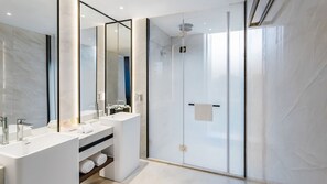 Een moderne badkamer met twee wastafels, een douchecabine van glas en een grote spiegel.