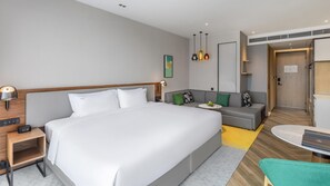 A modern hotel room with a large bed, a sofa, a small table, and a desk. - Holiday Inn Xi An Chanba (Xi'an)