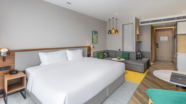 A modern hotel room with a large bed, a sofa, a small table, and a desk. - Holiday Inn Xi An Chanba (Xi'an)