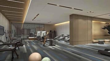 A modern gym with exercise equipment, a patterned carpet, and a large mirror.
