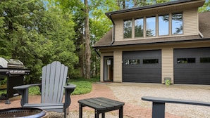 A modern house with a garage, a patio with outdoor furniture, and a grill. - 2 Bedroom Carriage House with view of Suttons Bay (Suttons Bay)