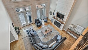 Un salón amplio con un sofá seccional grande, una mesa de centro y una chimenea.