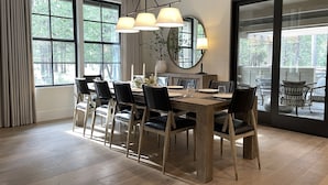 Ein Essbereich mit Holztisch, schwarzen Stühlen und einer Chandelüster.