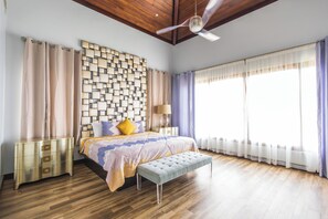 Relax in a stylish bedroom with a large bed, geometric-patterned headboard, and matching bench.