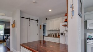 A kitchen with white cabinets, a wooden countertop, and a white stove. - Willoughby 4BR Coastal Home • Steps to Shore (Norfolk)