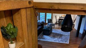 A wooden staircase leading to a living area with a fireplace, a sofa, and a dining table. - TreeTops in Town Private & Peaceful (Charleston)