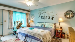 A bedroom with a bed, a rocking chair, a wall clock, and a window with curtains. - Southeast Michigan Escape w/ Outdoor Fun (Adrian)