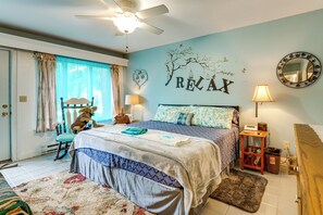 A bedroom with a bed, a rocking chair, a wall clock, and a window with curtains. - Southeast Michigan Escape w/ Outdoor Fun (Adrian)