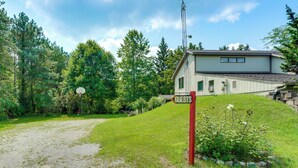 A house with a sign reading 'GUESTS' in front, surrounded by greenery and a gravel path. - Southeast Michigan Escape w/ Outdoor Fun (Adrian)