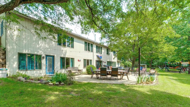 A two-story building with a patio area featuring outdoor furniture. - Southeast Michigan Escape w/ Outdoor Fun (Adrian)