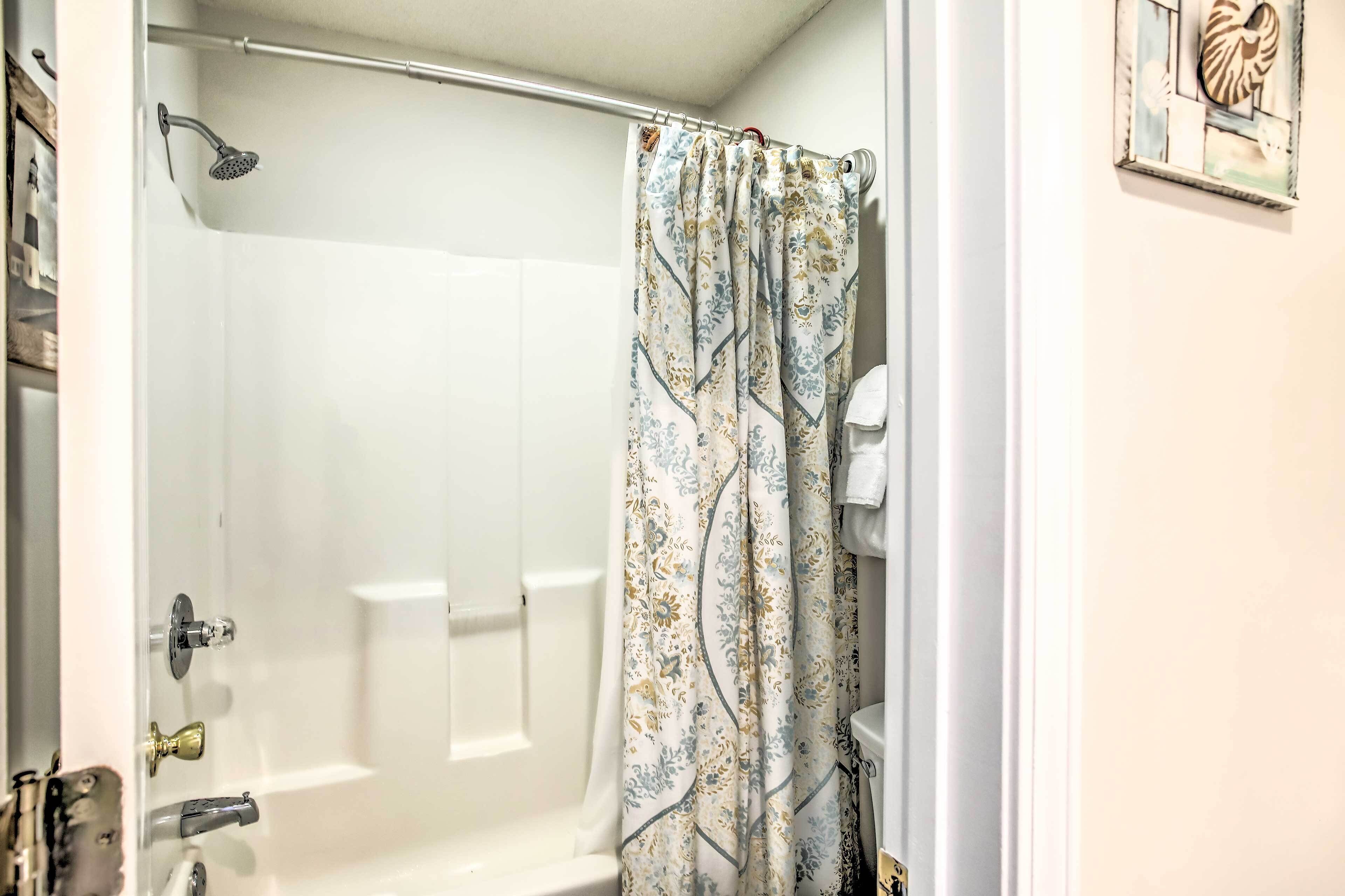A bathroom with a shower, a toilet, and a sink.