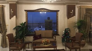 Un soggiorno con una grande finestra, un lampadario e un albero di Natale.