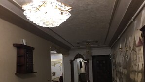 Un corridoio con un lampadario, un camino, uno specchio e un tappeto decorato.