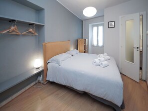 Un dormitorio ordenado con cama, mesita de noche y armario.