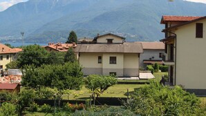 Zona residenziale con case, un giardino e una montagna sullo sfondo.