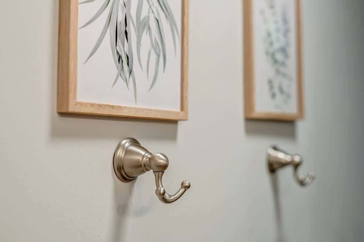 A door with a brass handle and a framed picture of leaves on the wall.