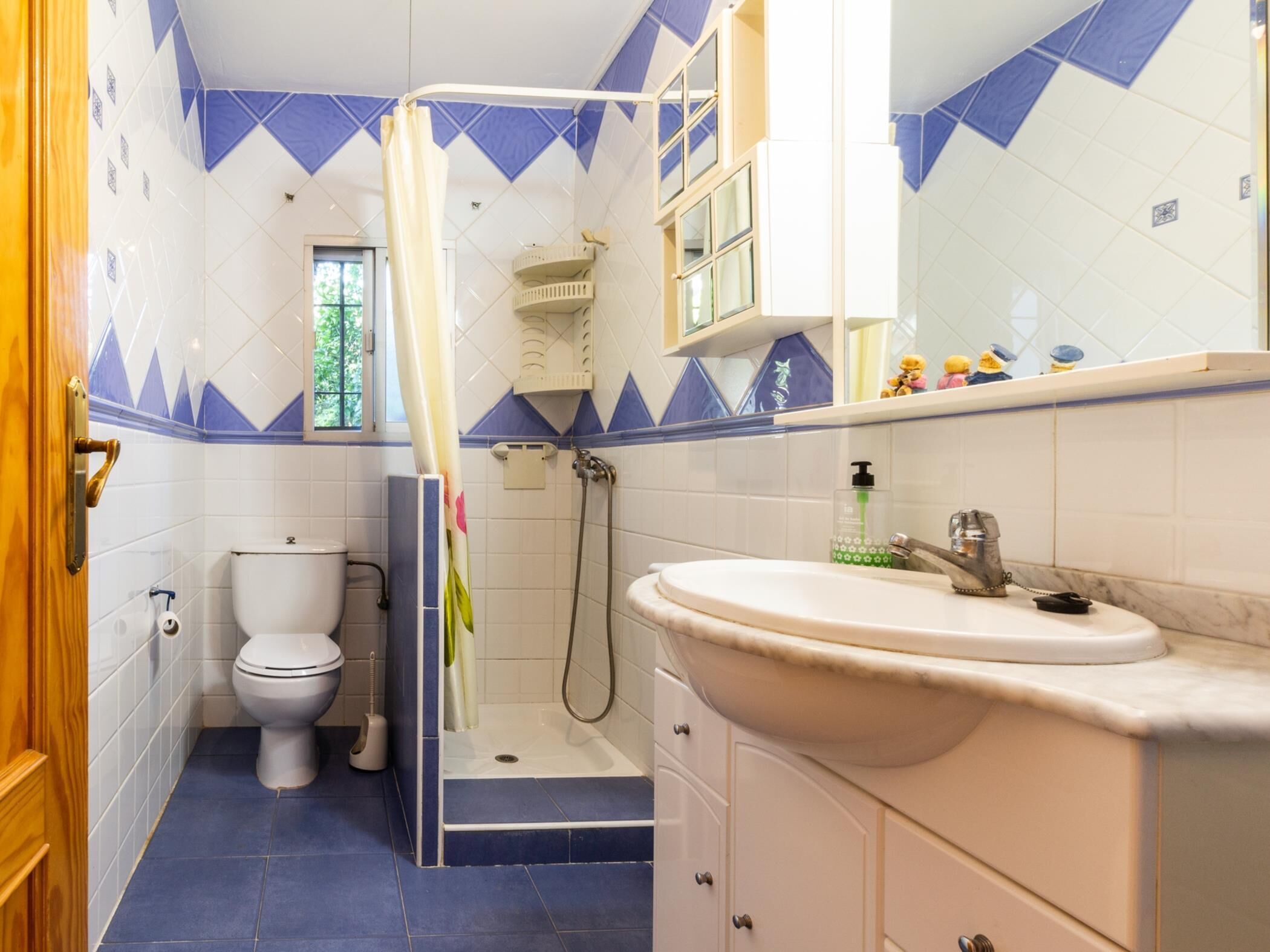 Un baño con inodoro, ducha y lavamanos.
