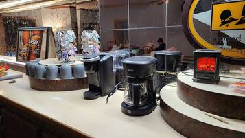 Eine Kaffeestation mit mehreren Kaffeeautomaten und einer Auswahl an Kaffeetassen.