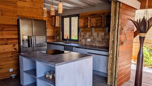 Une cuisine moderne avec des éléments en bois, un réfrigérateur en acier inoxydable et un grand îlot central doté d’un évier.