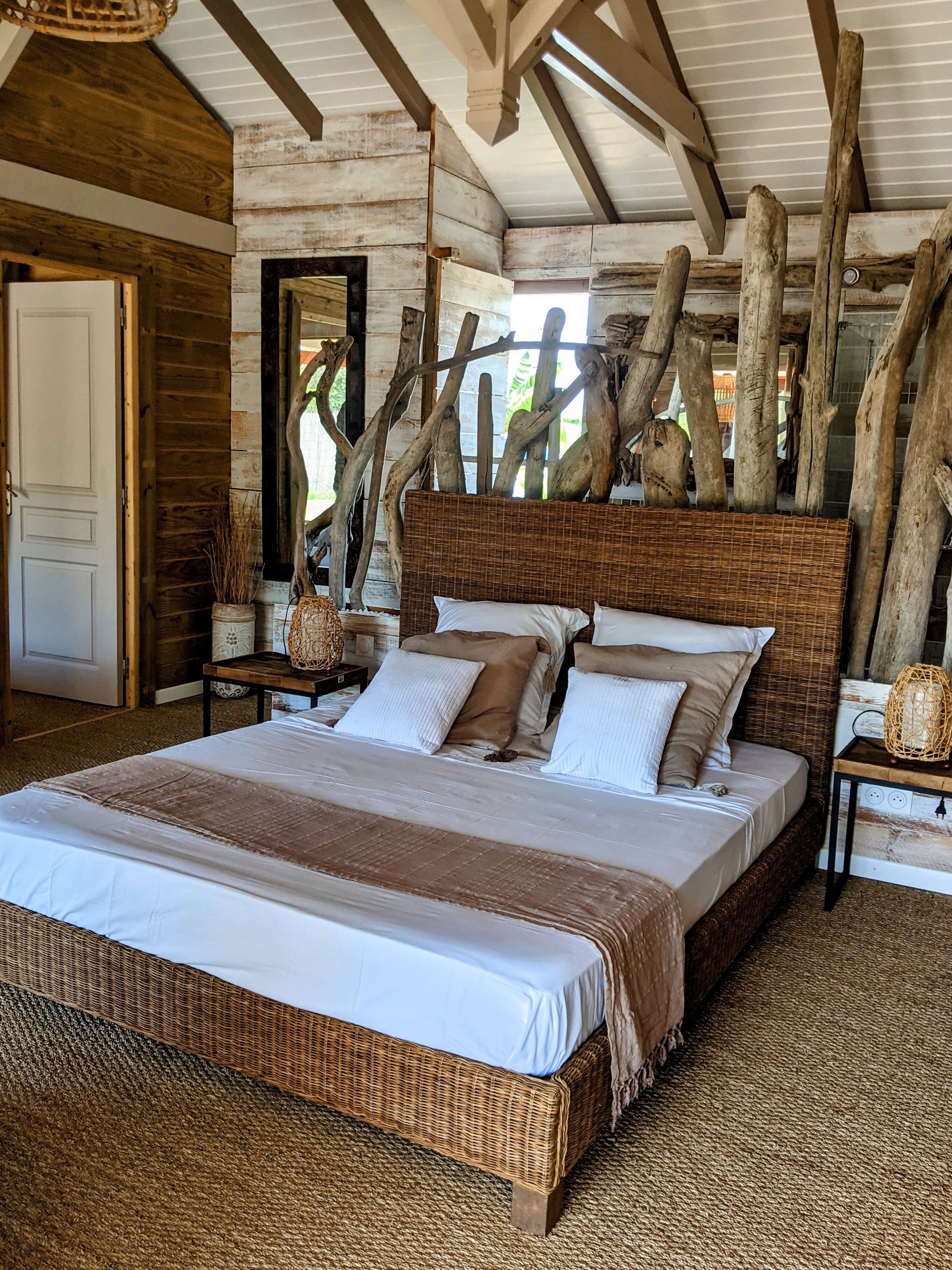 Une chambre spacieuse avec un grand lit, des poutres apparentes et un décor rustique.