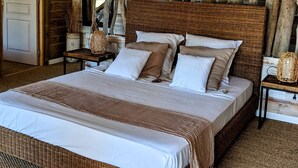 Une chambre spacieuse avec un grand lit, des poutres apparentes et un décor rustique.