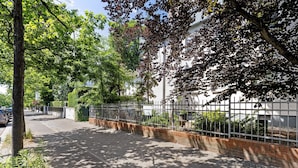 A paved pathway, a metal fence, and trees. - Centrally Located and Quiet Trade Fair Apartment Berlin (Berlin)