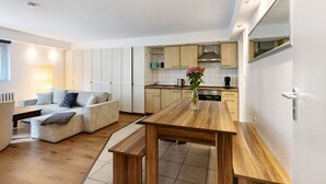 A modern kitchen with wooden cabinets, a dining table, and a built-in oven. - Centrally Located and Quiet Trade Fair Apartment Berlin (Berlin)