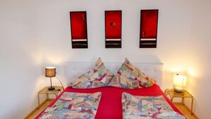 Een hotelkamer met een bed, twee nachtkastjes en drie wandlampen.