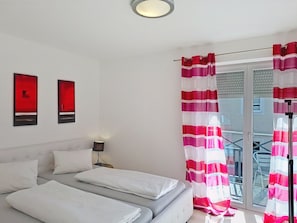 Ein Hotelzimmer mit einem Bett, einem Nachttisch und einem Fenster mit Vorhängen.