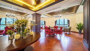 A spacious lobby with a wooden floor, red upholstered chairs, and a central table with floral arrangements. - Howard Johnson by Wyndham Yaan Forest Resort (Ya'an)