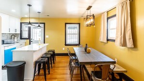 Cozinha moderna com ilha central, banquetas e iluminação pendente.