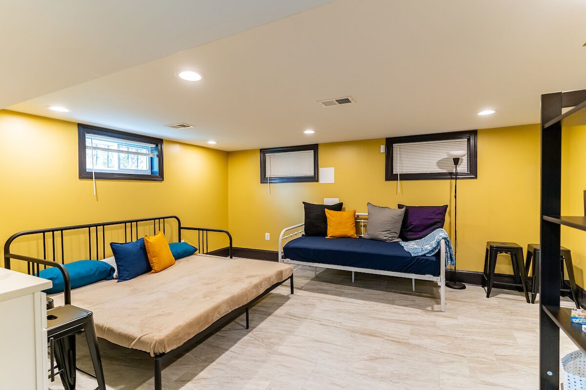 A compact room with two beds, a desk, and a window.