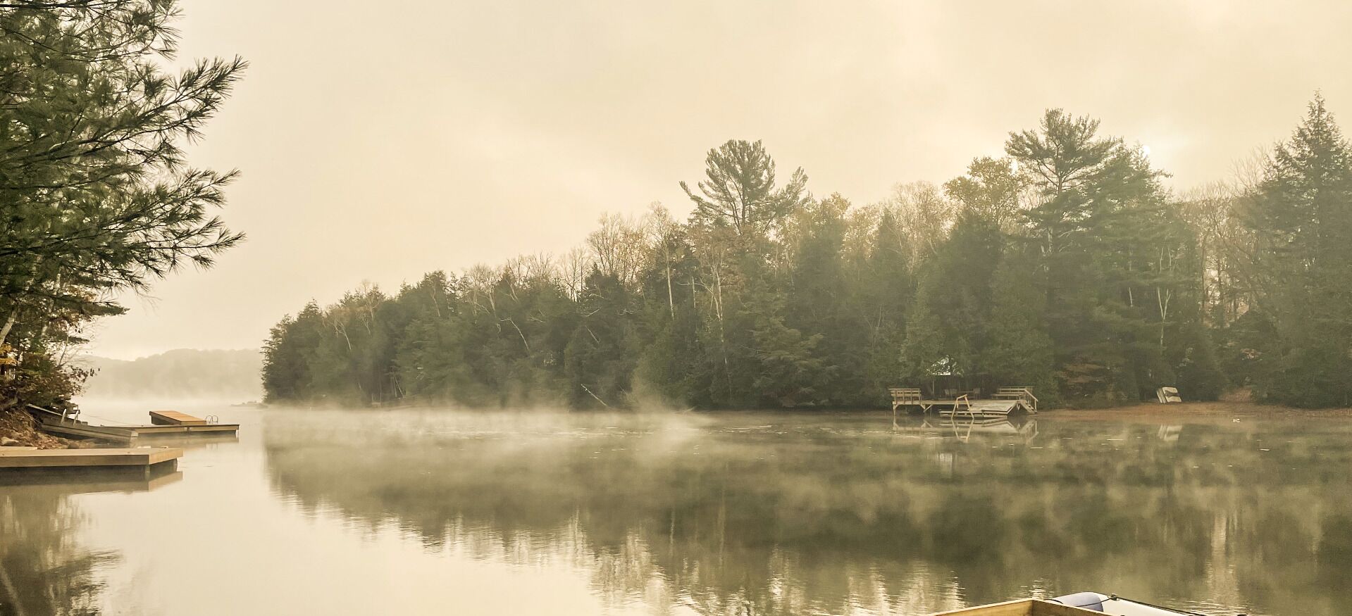 A calm lake with wooden docks and a gazebo.