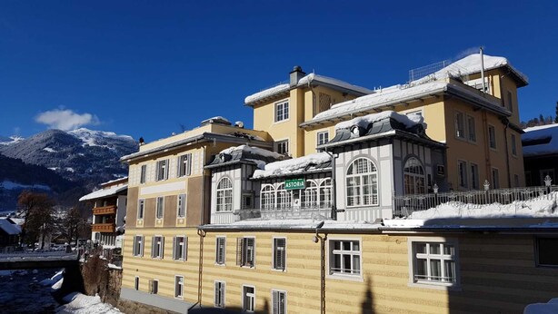 A multi-story building with a snow-covered roof and a sign reading 'ASTORIA.'