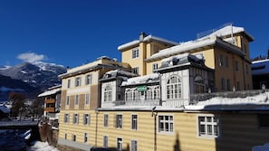 Un edificio de varios pisos con tejado nevado y un letrero que dice 'ASTORIA'.