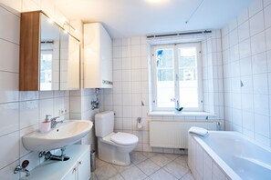 Ein modernes Badezimmer mit Waschbecken, Toilette und Badewanne.