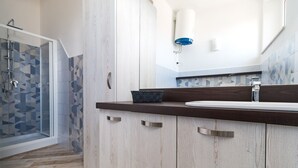 A bathroom with a shower, a sink, and a mirror. - Apartment Blu with Mountain View, Balcony, A/C & Wi-Fi (DORGALI)