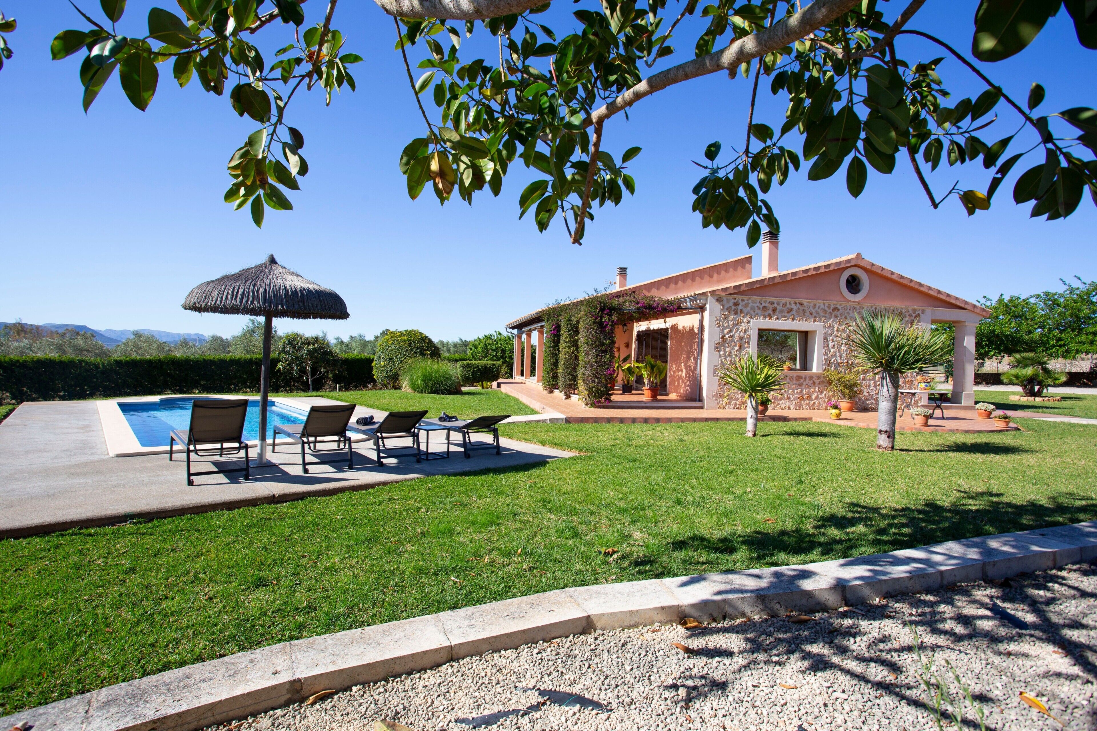 A house with a swimming pool, outdoor seating, and a garden.