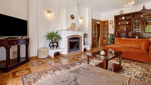 A living room with a fireplace, a television, a sofa, and a coffee table.