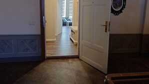 A hallway leading to a living area with a sofa and a coffee table.