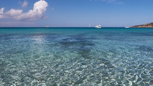 A clear turquoise sea with boats and a hill in the background. - Villa Pienezza 8p 4 bedrooms very quiet Pinarellu 5min from beaches Heated swimming pool (Pinarellu)
