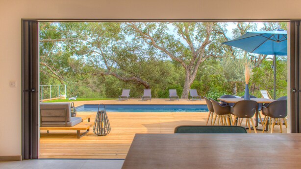 A wooden deck with a pool, outdoor seating, and a table with chairs. - Villa Pienezza 8p 4 bedrooms very quiet Pinarellu 5min from beaches Heated swimming pool (Pinarellu)