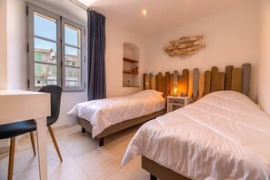 Ett hotellrum med två sängar, ett skrivbord och en stol.