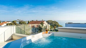 Ein Pool auf dem Dach mit freiem Blick auf das Meer und die umliegenden Gebäude.
